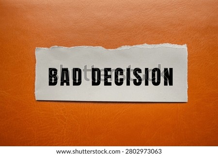 Bad decision message printed on a torn white paper strip, symbolizing mistakes, regret, and poor choices
