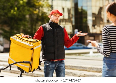 Bad Delivery Service. Courier Delivering Customer Wrong Package Shrugging Shoulders Standing Outdoors. Selective Focus