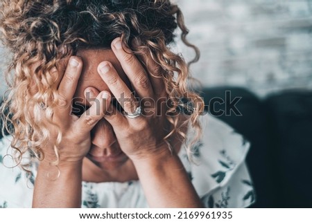 Bad emotions and problems for a worried and desperate woman holding head with hands. People and depression disease. Female wife after divorce or home violence crime. Mind unhealthy condition lady