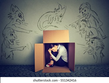 Bad evil men pointing at stressed woman. Desperate scared businesswoman hiding inside a box isolated on grey wall background. Negative human emotions face expression feelings life perception