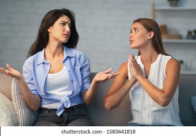 Bad Friendship. Girl Refusing To Do A Favor For Begging Friend Sitting On Sofa At Home. Selective Focus - Shutterstock ID 1583441818