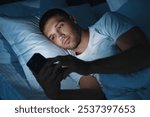 Bad habit. Man using smartphone in bed at night