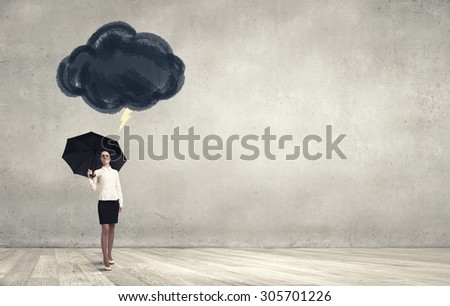 Bad luck and crisis concept with young businesswoman with black umbrella 