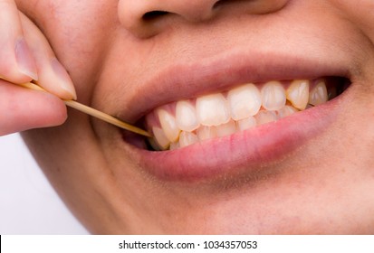 Bad Manners A Table. Bad Etiquette A Table. Asian Woman Clean Her Teeth From Food Stuck Her Teeth With Bamboo Toothpick After Breakfast, Lunch, Dinner. Rude Behavior. Uncultured And Impolite Habit. 