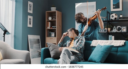 Bad Musician Playing The Violin For His Girlfriend At Home, She Is Annoyed And Disappointed