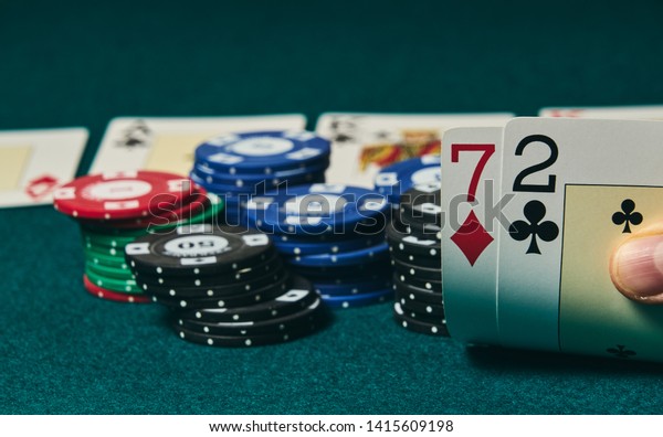 Bad poker gamble or unlucky hand concept with\
player going all in with 2 and 7 (two and seven) offsuit also\
called unsuited, considered the worst hand in poker preflop (before\
the flop is revealed)