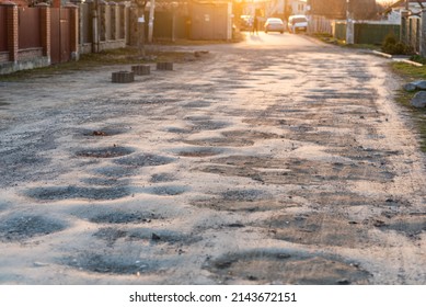 Bad road quality concept: old asphalt road full of holes and pits in need of repair - Shutterstock ID 2143672151