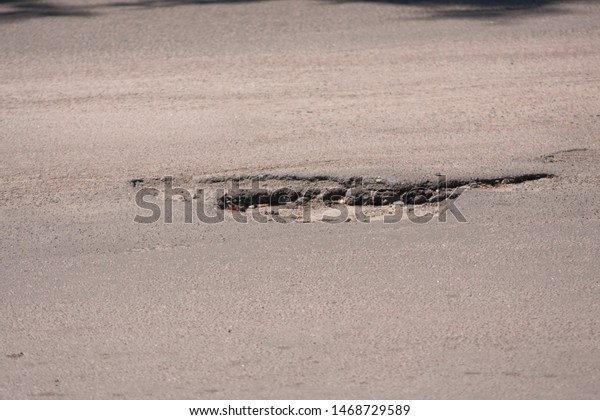 Bad roads. Hole in the\
asphalt, the risk of movement by car, bad asphalt, dangerous road,\
potholes in asphalt, pit unsafe hole road concept. Way markings in\
the pit.