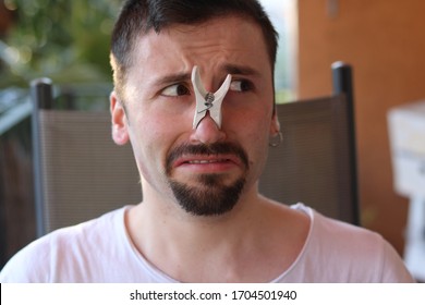 Bad Smell Concept, Clothes Peg On Nose. Young Man Looking Disgusted