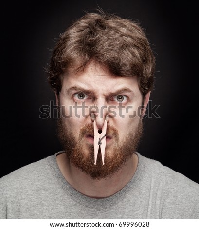 Bad smell concept - peg on male nostrils over black