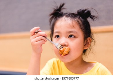 Bad Taste Face With Karaage Deep Fride Chicken.Japanese Fried Food.Little Asian Girl Face Bad Taste In Her Fried Chicken Have Cold And Sticky In Japanese Restuarant. Disappointed Face Concept.