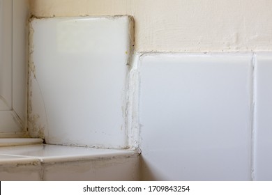 Bad Tiling DIY Disaster. Rogue Trader Or Do-it-yourself Fail. Ceramic Bathroom Tiles Badly Fixed And Grouted. Close-up Of Poor Handyman Work.