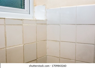 Bad Tiling. Terrible Bathroom Tile DIY Fixing And Grouting Job. Old White Ceramic Tiles With Untidy Grout After Do-it-yourself Or Rogue Trader Disaster. Job For A Professional Home Tiler Tradesperson