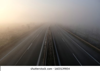 Bad weahter photography. High angle view of driving on a gray foggy day on the highway. Low visibility condition. Difficult and dangerous hazard for drivers. Drive safely in autumn and in winter.