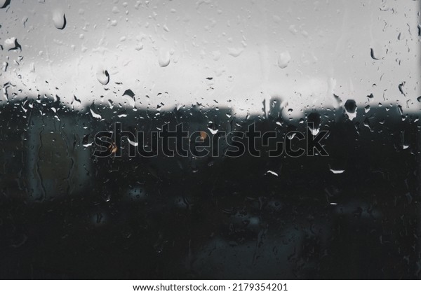 bad weather in the city. Buildings, houses, cars\
outside the window. Cloudiness cumulus clouds. Meteorology and\
weather forecast. Raindrops run down the glass. Storm and Storm and\
wind on city streets