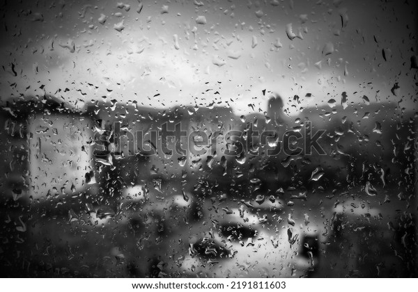 bad weather in the city. Buildings, houses, cars\
outside the window. Cloudiness cumulus clouds. Meteorology and\
weather forecast. Raindrops run down the glass. Storm and Storm and\
wind on city