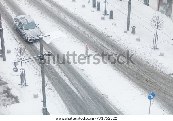 Bad weather conditions.\
Car on road covered with snow during winter time. High angle view\
from top.