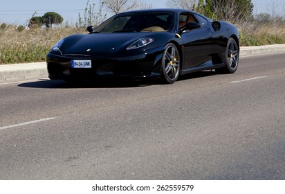 BADAJOZ, SPAIN - MARCH 14, 2015: Ferrari Car show at Badajoz City on Complejo Alcantara resorts, March 14, 2015. Black Ferrari F430 spider on the road
