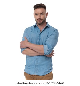 Badass Casual Man With Blue Shirt Standing With Hands Crossed Confident On White Studio Background