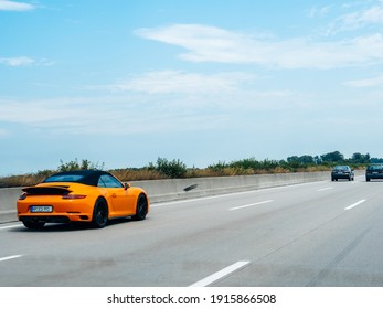 Baden-Baden, Germany - July 7, 2019: Fast motion on the German autobahn of an orange Porsche 911 sportcar