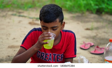 Badhal, Jaipur, India-16 March 2020;
An Cute Indian Kid Taking Cold Soft Drink In Summer Hot Day. Attractive Boy Wearing Red T Shirt. 