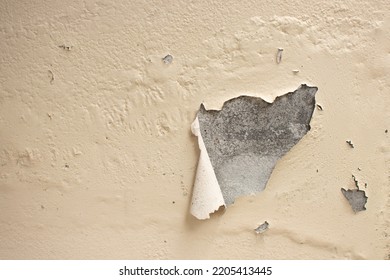 Badly damaged old wall with peeling off paint. Patches of paint are missing