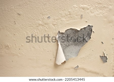 Badly damaged old wall with peeling off paint. Patches of paint are missing