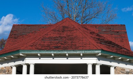 A Badly Damaged Roof Made Of Red Shingles