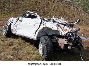 A badly wrecked vehicle involved in a rollover accident.