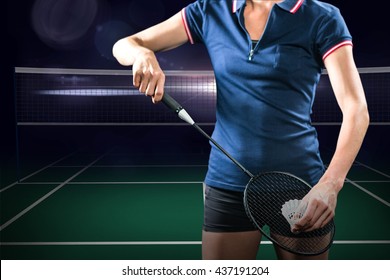 Badminton player holding a racket ready to serve against view of a badminton field - Powered by Shutterstock