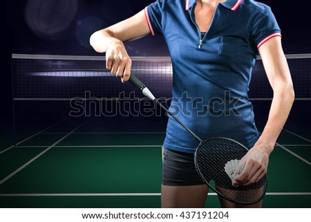 Badminton player holding a racket ready to serve against view of a badminton field