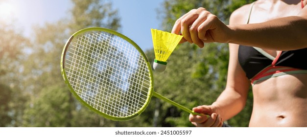 Badminton racket and shuttlecock in woman's hands. Sporty woman in bikini playing badminton outdoors in summer. Active lifestyle. - Powered by Shutterstock