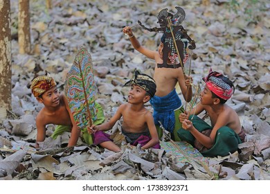 Badung, Bali Province, Indonesia, November 8, 2014: A Group Of Boys Are Playing Shadow Puppets Which Is Traditional Balinese Art With Great Excitement.