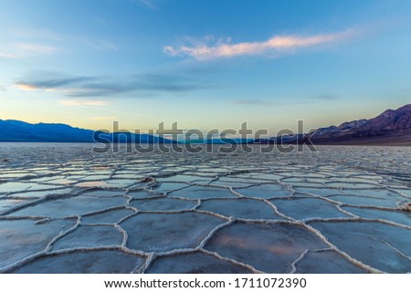 Badwater Basin at Sunset. Salt Crust and Clouds Reflection. Death Valley National Park. California, USA