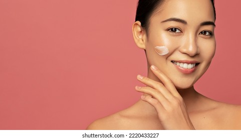 Baeuty portrait. Facial cream. Hydration and skin care concept. Young beautiful asian model posing with applayed cream on her face - Powered by Shutterstock