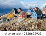 Baffin Bay, colorful typical houses in small village Uummannaq, Greenland Icefjord in Greenland and the silhouetted hight mountain ridge in the background under a blue
Melting icebergs by the coast.