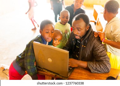 Bafoussam, Cameroon - 06 August 2018: Young African Teacher Involve School Children In Learning Technology With Computer In Classroom