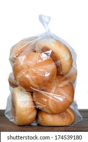 A Bag Of Bread Bun On Table Against White Wall