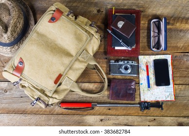 Bag With Contents To Travel On The Background Of The Old Board