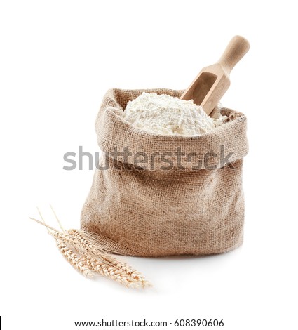 Bag with flour and wooden scoop on white background
