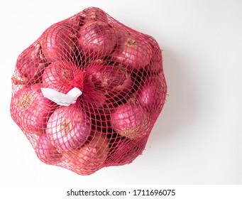 A Bag Full Of Red Onions On White Background. 
 These Onions Are Widely Used In Many Cuisines. They Appear Red To Purple In Nature. An Essential Ingredient In Everyday Cooking.