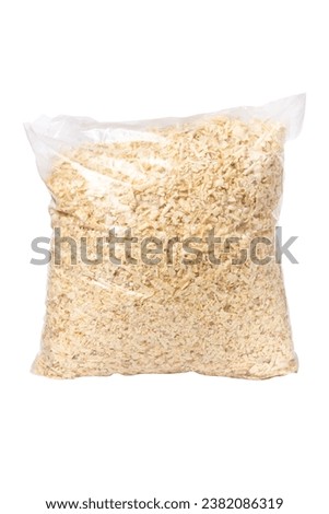 The bag is full of wood shavings. Wood shavings isolated on a white background.