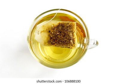 The Bag Of Green Herbal Tea In A Glass Bowl With Water, Isolated On A White Background