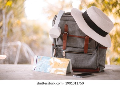 Bag, hat, map and headphones on Vacation day.