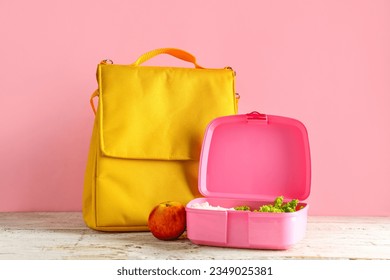 Bag and lunchbox with tasty food on white wooden table near pink wall - Powered by Shutterstock