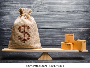 A Bag Of Money And A Bunch Of Boxes On The Scales. Conceptual Trade Balance Between Countries And Unions, Trade And Exchange Of Goods. Economic Relations Between Subjects, The Global Economic Model.