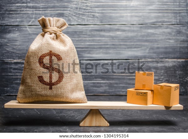 A bag of money and a bunch of boxes on the scales.
Conceptual trade balance between countries and unions, trade and
exchange of goods. Economic relations between subjects, the global
economic model.