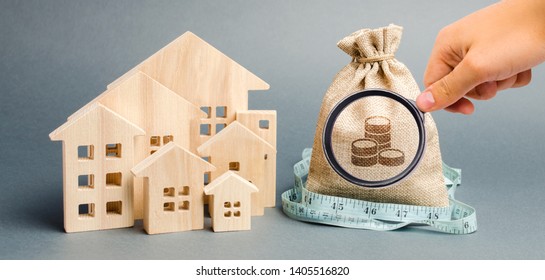 Bag With Money And Tape Measure With A Wooden Houses. The Concept Of A Limited Real Estate Budget. Low Subsidies. Lack Of Investment In Construction. Market Crisis. Bankruptcy