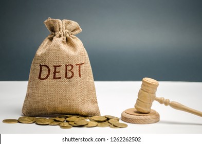 A bag of money and the word Debt and the hammer of the judge. Payment of taxes and of debt to the state. Concept of financial crisis and problems. Risk management. Debt exemption. Credit and loan