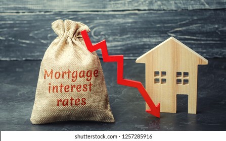 Bag with the money and the word Mortgage interest rates and arrow to down and house. Low interest in mortgages. Reducing interest payments for mortgages. The fall in housing rates on credit. Low